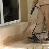 General pest control technician spraying exterior perimeter around a home in Las Vegas, NV